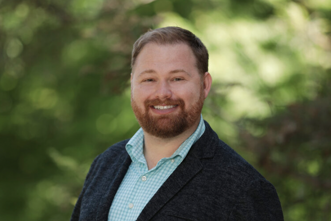 Paul David Terry Portrait on a man with red hair and a beard, standing outside.