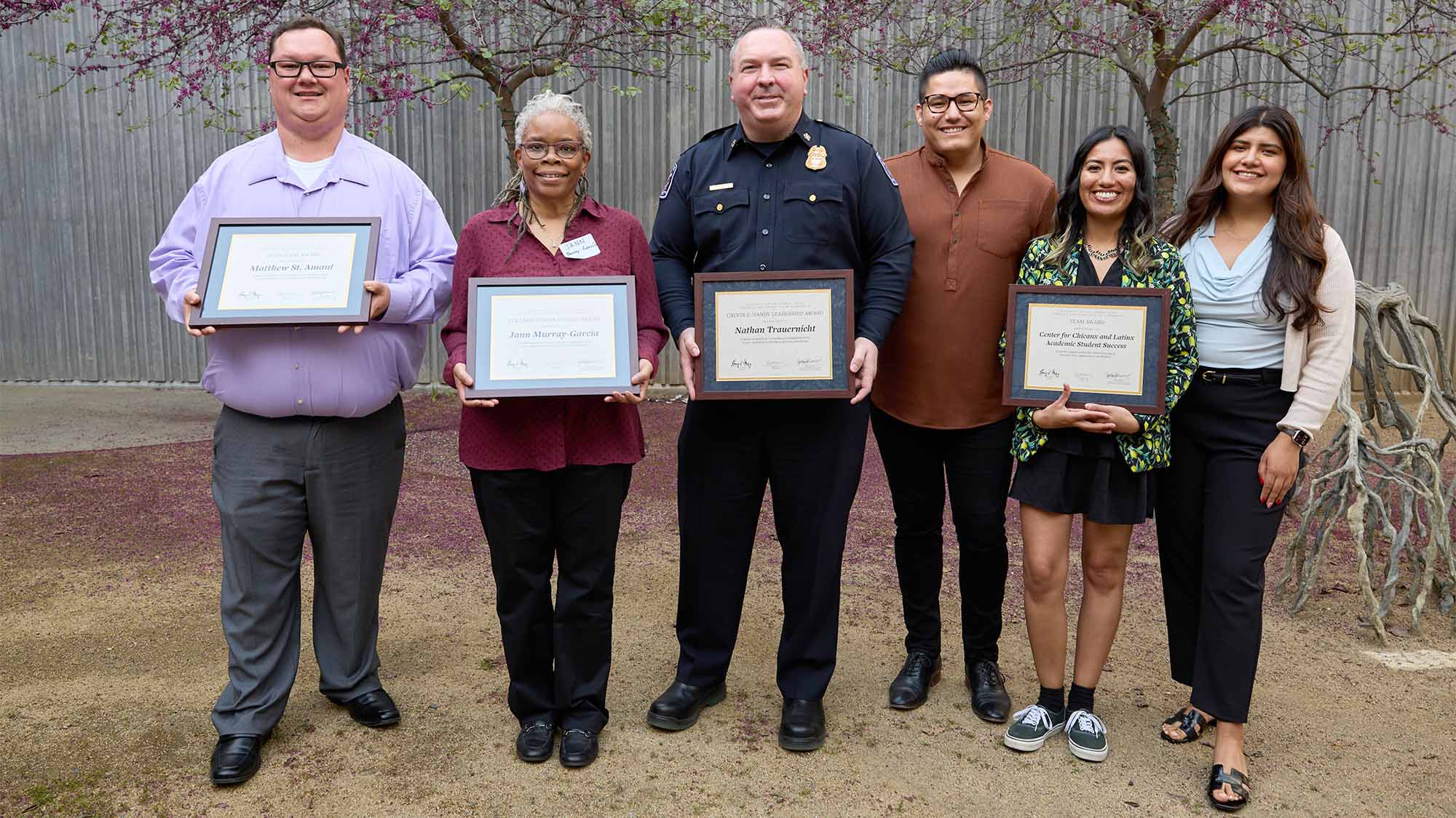 six people stand together holding certificates to show receiving Soaring to New Heights award