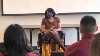 From the vantage point of an audience member, Renetta G. Tull casually seated and speaking to an audience
