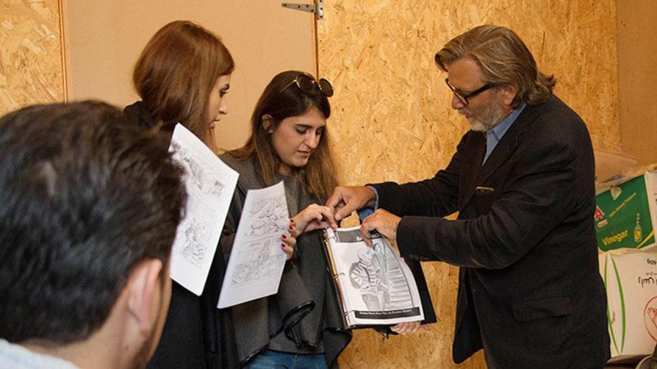 UC Davis professor Keith David Watenpaugh, right, and two trained guides from the American University in Beirut use a comic book to explain Article 26 Backpack at a refugee camp in Lebanon as Jihad Qusanyeh looks on. (Liz McAllister/UC Davis) banner image