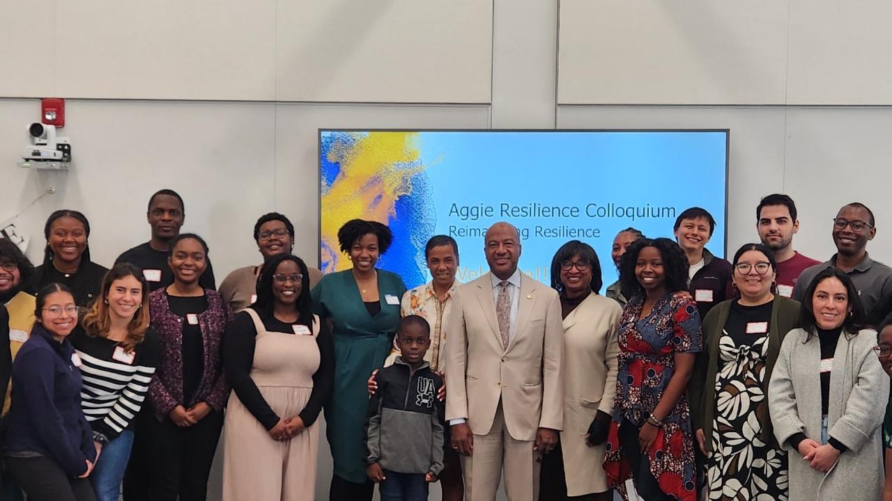 Doreen Joseph, Vice Chancellor Renetta Garrison Tull and Chancellor May stand with a group of about 30 people at Aggie Resilience event