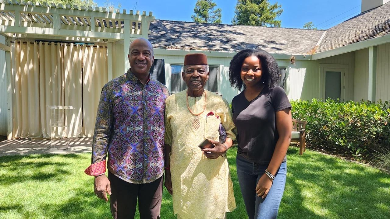 Chancellor May, Professor Augustine O. Esogbue and Doreen Joseph stand in courtyard at Chancellor's residence.