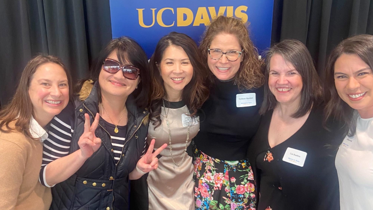 Six women stand together for a photo, one woman is holding up a peace sign.