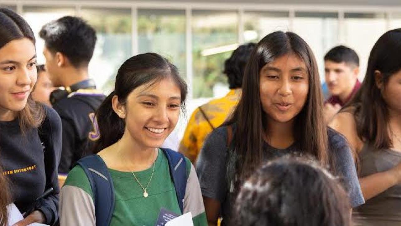 Latinx college-aged students smiling, gathered together