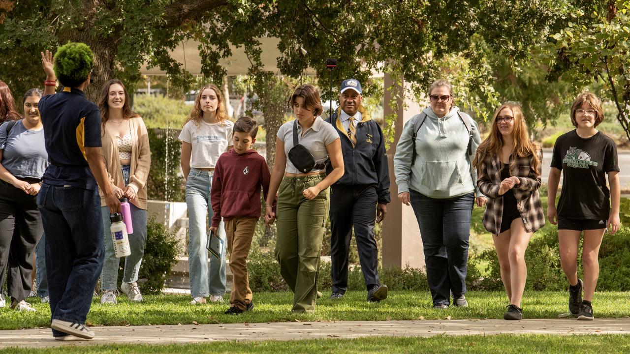 Prospective students tour UC Davis. UC Davis Chancellor Gary May is with the group posing as a prospective parent.