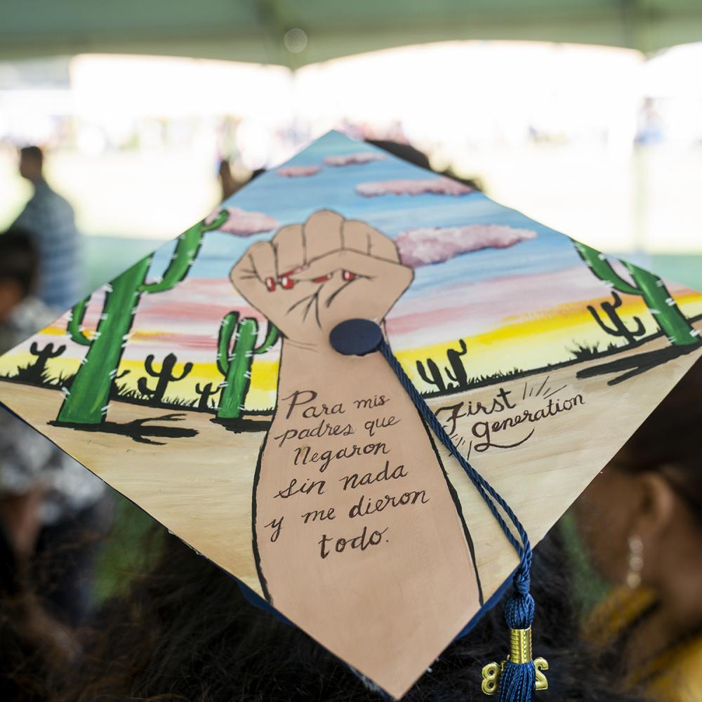 Decorated graduation cap with a fist and the words "para mis padres que Negaron sin nada y me dieron todo. First Generation"