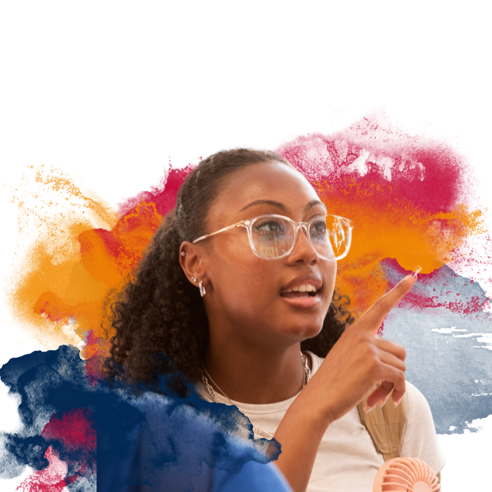 A person with curly hair and glasses points forward against a backdrop of colorful abstract splashes.