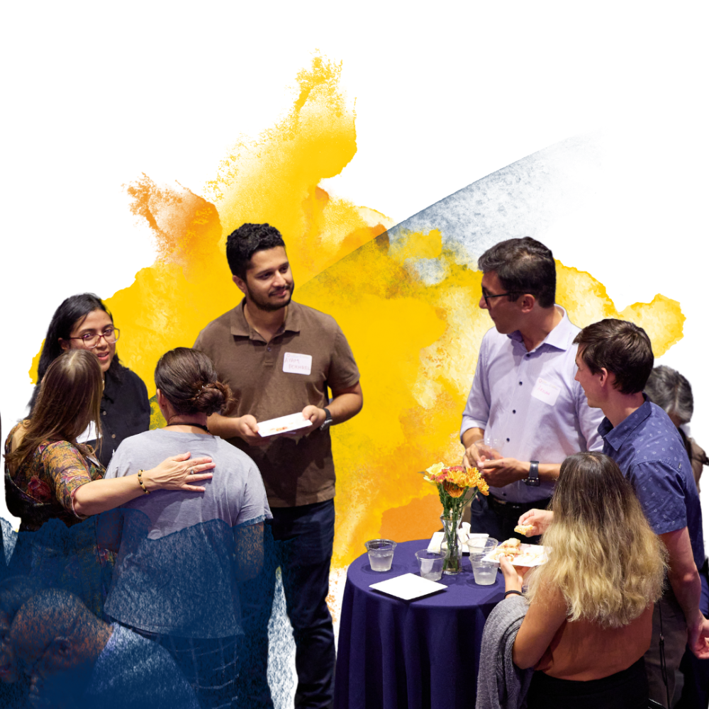 People socializing around a table with a colorful abstract background.