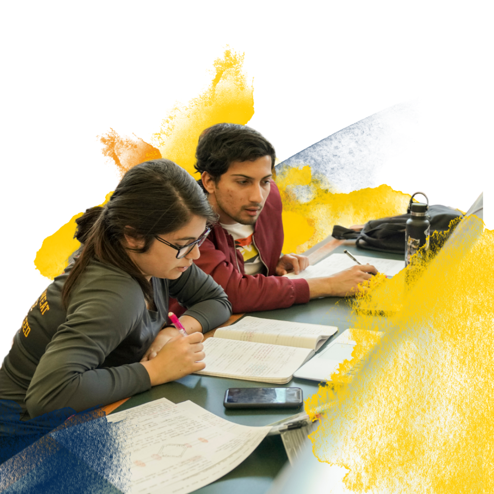 Two people studying at a table with colorful splashes in the background.
