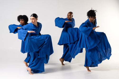 four dancers in blue costumes from dance company
