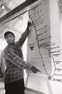 Cesar Chavez stands in front of a map detailing the route of the 1966 march.