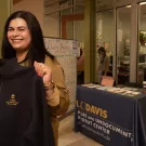 Doctoral candidate Adriana Quintana-Lopez holds up a sweatshirt with the new logo of what will now be called the Undocumented Student Resource Center. 